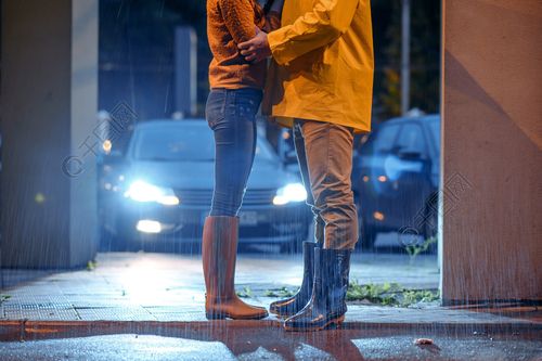 在夜公园爱夫妇约会夏天下雨天男人和女人在雨中浪漫的约会在人行道上